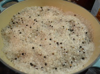 3) 鍋中倒入粗鹽和胡椒碎，開中火慢慢炒至聽到鍋內鹽發出＂嗞嗞＂聲響，大約7分熱。