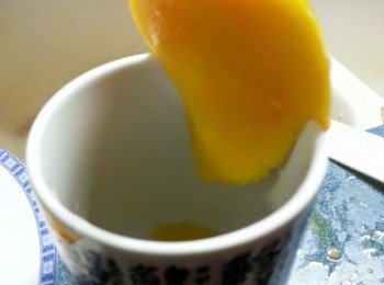 step5: 芒果去皮，用杯沿果核切下果肉，再切成件