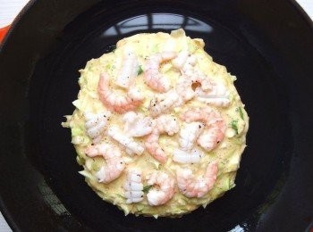 step6: 麵糊煎至適當程度時,鋪上海鮮及培根等材料。