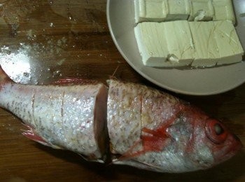 step2: 在紅喉的身上抹上鹽和白胡椒後，斜劃數刀（以利入味），再將紅喉對切（因為蘋果姊姊手邊的這尾紅喉很大，所以要對切，才放得進盤子裡）。