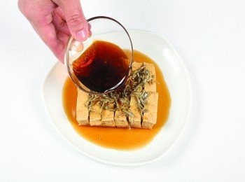 step8: 把炸過的鯷魚乾放在豆腐上，並淋下<span class="group_2">調味醬</span>。