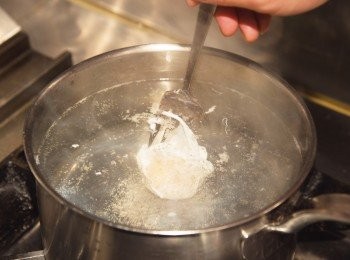 step2: 製作水波蛋。先把雞蛋打在小碗中。 鍋裡放入大量熱水煮沸後倒入醋(比例大約是1ℓ的熱水加3大匙醋)，用湯瓢等在鍋裡繞圈製造出漩渦。 沿著鍋緣內側慢慢倒入雞蛋。煮2分鐘後輕輕撈起。
