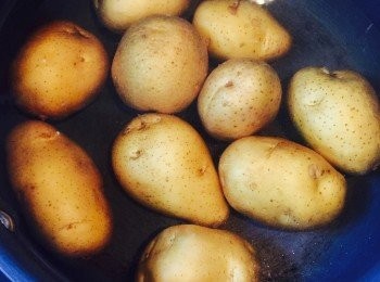 step1: 將新薯表面擦洗乾淨，每粒用刀?一個十字，放入已煮滾的鹽水中，煮約20分鐘至熟透。瀝乾待涼，用刀把薯仔皮撕去，切粒備用。紅洋蔥先切半泡水，切粒。