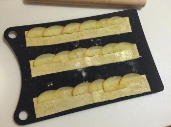 step4: 在條狀酥皮上塗上薄薄一層杏桃果醬, 將蘋果片帶皮的圓弧型的邊邊朝上方, 整齊放置在酥皮的邊緣, 上方露出約1/3的蘋果片 (露出的部份為圓弧型的邊邊)