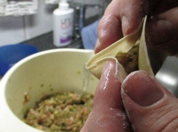 step2: 包法和包水餃一樣，取適當的餡料於餛飩皮正中央，四邊周圍用清水沾勻。