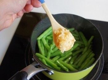 step3: 四季豆水份漸漸變少之後將四季豆推到鍋子一側，另一側加入蒜末爆香