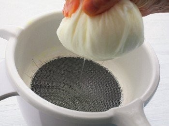 step8: 如果沒有時間的話，也可以將倒入優格的廚房紙巾，抓住紙巾邊緣，用擰擠的方式擠出水分（圖七）。