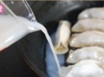 step12: 淋入麵粉醋水，醋可以是米醋也可以是香醋。蓋上鍋蓋，見底部水分蒸可以在繼續少許添加，直至煎餃熟即可。如果想要底部帶脆底花紋的，可以一次加水約1/3處，蓋上鍋蓋，直至鍋底水份蒸發，形成脆皮似得脆底即可出鍋