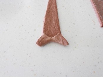 step4: 每塊麵糰，拿起，用雙手稍微拉長。放在桿麵台上，從底部捲起。