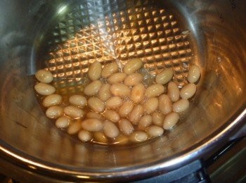 step4: 打開鍋蓋,去除昆布乾,蒜碎及辣椒,前傾鍋子將黃豆浸泡湯汁,用中火邊拌勻邊加熱,煮至收乾即可.