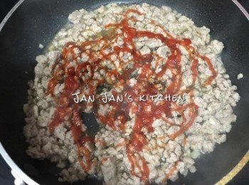 step2: 下油爆香蒜蓉，放入肉碎炒勻1分鐘，其間要壓碎肉粒。再加入少許熱水、蕃茄醬、喼汁及少許糖調味，小火慢慢煮熟。