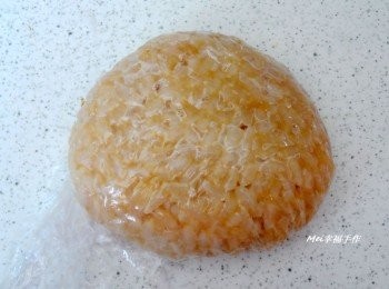 step1: 將白飯趁熱加入醬油膏攪拌均勻，再用保鮮膜先捏出一個稍稍呈三角形的樣子當頭部，接著再用保鮮膜捏出二個耳朵，然後放在頭部二側