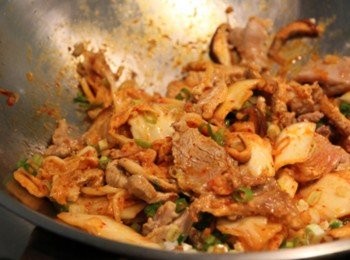 step3: 鍋倒油加熱放入蒜末炒香加入香菇片拌炒，加入泡菜與肉片一同炒香入味即完成。