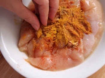 step2: 雞里肌倒入少許米酒略醃10分鐘。將咖哩粉、匈牙利紅椒粉、辣椒粉、蒜粉、孜然粉、鹽倒入用手均勻攪拌，放入冰箱醃至15分鐘，倒入橄欖油拌勻。