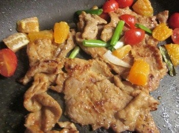 step4: 肉片挑起醃過的橘子不要,鍋中放油煎肉片至金黃微焦可先盛起,原鍋再加一點點水放入小蕃茄,橘子丁炒到邊邊微軟入味(可試一下味道不夠鹹再加塩)起鍋前放青葱段稍拌即可上桌
