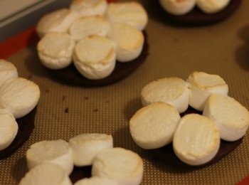 step7: 棉花糖切半，將烤好的半份巧克力無比派翻過來，擺上切半棉花糖，放在鋪有烤布或烤紙的烤盤上，送進350度F(約180度C)的烤箱上層，烘烤約3~4分鐘至棉花糖表面略烤成金黃色取出，與另外半份巧克力無比派組合，即完成。