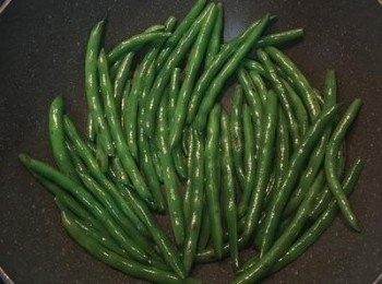 step4: 炒鍋放適量的油燒熱，待鍋子燒熱後，放入四季豆與少許的鹽乾炒；需儘量鋪平，讓四季豆都能接觸到鍋底，炒到四季豆表面出現燒痕，便可起鍋備用。