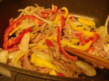 step6: 6.當牛肉約炒至7分熟度時加入黃椒和紅椒ˊ並嗆入米酒和胡椒粉再次拌炒
