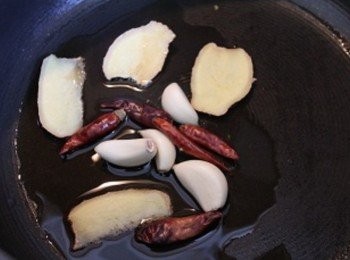 step1: 用麻油中火爆香蒜頭, 薑片, 與乾辣椒 (** 不敢吃辣的, 乾辣椒可以省略不用)