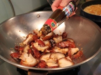 step2: 將鮮蝦放入燙麵水中川燙取出。鍋倒入少許油，放入臘腸煎香，放入蹄膀片炒出香氣，