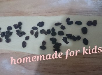 step6: 5.將每一個粉團碌扁成長條型，將提子乾平鋪於粉團上再卷起放入模具。最後發酵10 分鐘