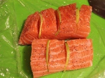 step2: 鮭魚排畫刀但不切斷, 切縫中間塞入檸檬薄片, 表面灑上少許的鹽巴/黑胡椒調味