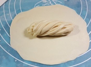 step13: 將一粒大粉糰40g用麵棍搓成一塊大圓形,將卷成條形的粉糰放在中間