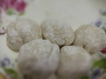 step9: 待糯米團冷卻，捏一團糯米團在保鮮紙上，壓平糯米團，放上芒果，然後對摺壓平了的糯米團，再輕力塑成圓狀。最後，沾上糕粉。
