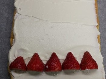 step8: 牛油紙鋪底，放上蛋糕，再抹上已雪凍既忌廉
蛋糕邊位放上已切半的士多啤梨