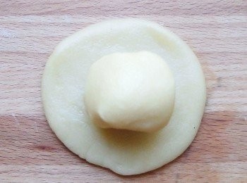 step10: 將<span class="group_2">油皮麵皮</span>壓扁擀開,光滑面在外,包上一個<span class="group_3">油酥麵皮</span>。