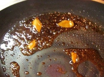 step2: 原鍋加入麻油爆香薑片,加入水30cc.糖1茶匙.醬油20cc.酒10cc