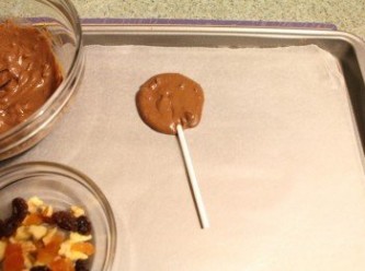 step4: 用小湯匙挖一小瓢巧克力放在烘培紙上, 並鑲入棒子