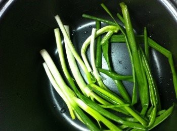 step2: 在電飯煲底放上蔥，再將所有排骨倒入。