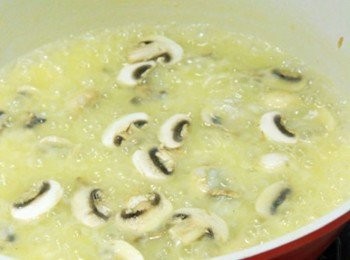 step2: 鍋倒少許橄欖油炒香蒜、洋蔥碎炒香。倒入美國玫瑰米用木匙稍微攪拌讓米粒沾滿橄欖油與洋蔥香氣，倒入白酒火轉大些將酒精蒸發後轉小火，倒入蛤蜊湯蓋過米粒，用木匙用稍微輕輕劃圈(不要過度攪拌米粒容易破碎)，待高湯稍微收汁再倒高湯續煮，重覆這方法直到喜歡吃的燉飯口感後，炒至約6~7分熟時放入洋菇炒熟。