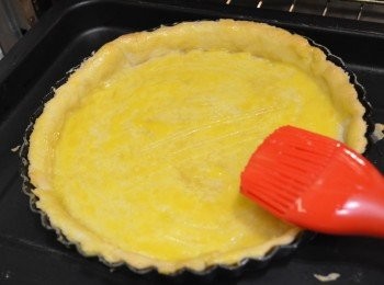 step9: 取出烤過的餅皮，移除烤石與烘焙紙，在餅皮的表面均勻掃上一層薄薄的蛋液。