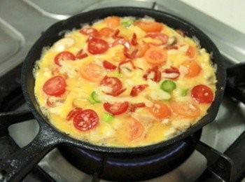 step4: 倒入烘蛋液後，上頭灑上西班牙辣香腸細絲、小火加熱於底部蛋液凝固後，烤箱預熱心180度烤5分鐘即完成