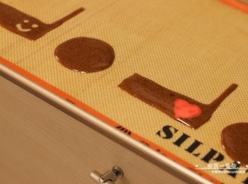 step10: 將事先畫好的餅乾模板，墊在不沾烤布或烘焙紙下，先填上少許咖啡薄餅麵糊，再以牙籤照模板勾勒出形狀(1個L型、一個圓形)。 利用步驟8完成的裝飾麵糊，畫上喜歡的圖案。