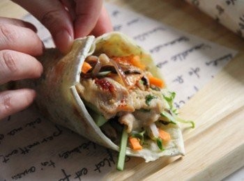 step6: 平底鍋倒少少油加熱放入蔥油餅兩面煎香取出放於盤上，依序將小黃瓜絲、紅蘿蔔絲、木耳絲、香菇絲、炒肉片、泡菜放在蔥油餅上，抹上適量韓式辣椒醬後，將蔥油餅捲起用防油紙捲成一花束即完成。