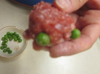 step4: 將豌豆鑲上3.當金魚的眼睛,取一張餛飩皮折皺摺黏在絞肉團下當金魚的尾巴