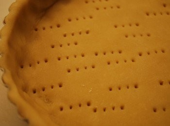 step1: 將冷凍派皮桿成3mm厚度圓形，略大於6吋派模，派皮鋪上派模，再沿邊緣將多於派皮切除，用叉子戳洞 (若用不可脫底派模，可先抹上一層無鹽奶油以防沾黏)