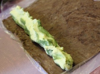 step9: 9.將可可麵糰的膠袋剪開，放入扭紋麵糰在邊緣，利用膠袋協助下卷起包實。