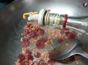 step6: 白鑊先爆香臘腸,迫出臘腸油份再加入蝦米,讚少許酒炒勻