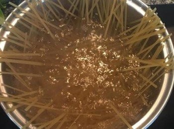 step9: 同時間煮滾ㄧ鍋水，水滾後放2茶匙鹽，下義大利麵煮到自己喜歡的硬度後，瀝乾麵條。將煮好的豬排取出，放些醬汁備用。接著將義大利麵放入起司茄汁中拌勻。裝盤後擺上豬排，淋上適量醬汁，並撒上少許切達起司粉，擺上ㄧ朵羅勒即可。