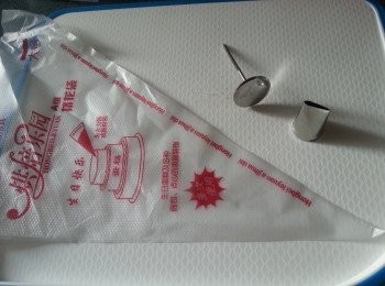 step7: 準備好用具,將紫薯放入唧袋,唧出玫瑰花放上牛油紙上,唧玫瑰花方法可參考以下網上朋友提供的片段:
https://www.youtube.com/watch?v=EAotBj1Ha8A
唧好的玫瑰花蓋上保鮮紙放入雪櫃待用
(需留起部份紫薯做餡)