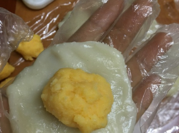 step7: 取一糯米團，按扁後，放上奶黃餡，收口，沾上椰絲即可食用。