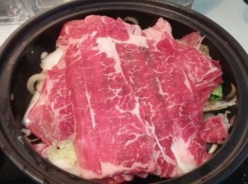 step3: 牛肉片平鋪於蔬菜面, 加入壽喜燒醬汁,加蓋焗一分鍾至牛肉片半熟。