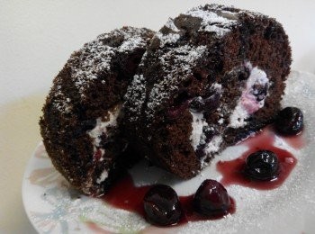 step7: 将打发的淡奶油涂抹在冷却的蛋糕片上。
均匀撒上沥干的自制的黑=樱桃或者罐头黑樱桃嗄上。
将蛋糕卷起来，用油纸包上，放入冰箱冷藏1个小时。在表面撒上糖粉混做装饰，就可以吃了。亚洲5小时之内食用最佳，欧洲2小时即可。