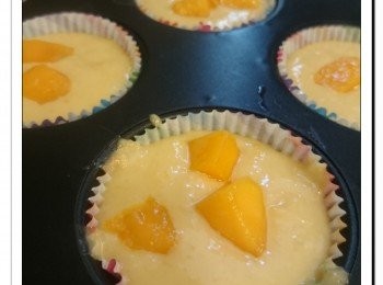 step9: 加入蛋糕液至9成滿。再把芒果粒放在表面。
