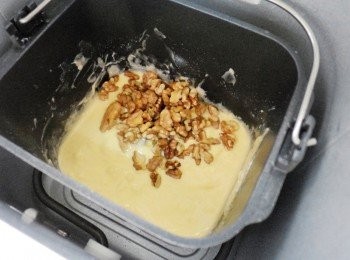 step6: 約12分鐘後ˊ使用橡皮刮刀將攪拌容器周圍粉末刮入麵糊中ˊ (這樣完成的蛋糕才不會有麵粉殘留)然後順便擺入烤香的核桃ˊ 蓋上蓋子再次開始ˊ完成取出略為放涼再切片