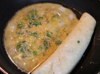 step3: 熱油鍋, 倒入一半的蛋液後, 放適量的起司香菜內餡. 待蛋皮周圍熟了之後, 將第一層蛋皮捲起後, 在鍋中倒入剩下的蛋液與起司香菜餡